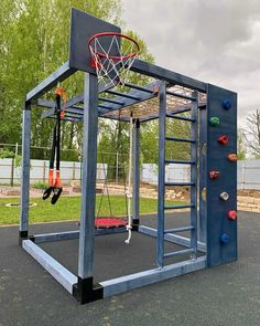 an outdoor gym with a basketball hoop and climbing wall