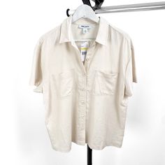 Add A Touch Of Sophistication To Your Wardrobe With This Elegant Nine West Women's Beige Solid Collar Short Sleeve Button Down Blouse, Available In Sizes Medium And Large. Crafted From High-Quality Materials, This Blouse Features A Classic Beige Hue And A Stylish Collar Design, Perfect For Both Casual And Formal Occasions. Whether You're Dressing For The Office Or A Weekend Brunch, This Versatile Blouse Offers Comfort And Style In One Chic Piece. Key Features: Brand: Nine West Gender: Women's Type: Blouse Style: Button Down Color: Beige Sleeve Length: Short Sleeve Closure: Button Down Available Sizes: Medium, Large Elevate Your Look With This Timeless Blouse That Pairs Effortlessly With Je Beige Collared Shirt For Day Out, Collared Beige Shirt For Day Out, Spring Beige Button-up Blouse, Classic Beige Blouse For Summer, Classic Linen Blouse For Day Out, Cream Linen Top With Buttons, Cream Linen Tops With Buttons, Beige Summer Shirt With Button Closure, Cream Shirt For Spring Workwear