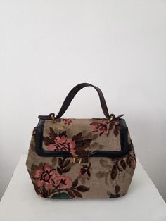 Vintage burnout velvet flora carpet bag in excellent condition.  Leather hand in great condition with aged condition.  Velvet has flattened under brass closure from years of use. Interior has zip pocket and 2 extra pockets.  Purse is clean with no stains or odors. Fabric colors a bright and vibrant. 12.5" wide 13" tall with handle up, handle drop is 4.5" 5" deep Vintage Beige Tapestry Bag, Vintage Beige Satchel, Vintage Floral Print Shoulder Bag, Vintage Beige Handheld Bag, Vintage Beige Shoulder Bag With Handles, Vintage Brown Bags With Floral Print, Vintage Tapestry Travel Bag, Antique Tapestry Bags For Everyday, Vintage Evening Satchel With Leather Handles