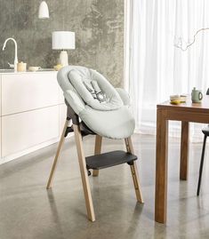 a baby highchair sitting on top of a wooden table