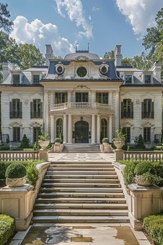 a large white mansion with steps leading up to it's front door and entry way