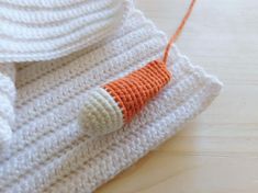 an orange and white crocheted object on top of a wooden table