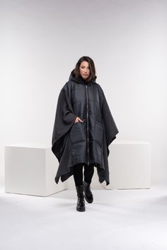 "Stay warm while staying fashionable with this unique puffer jacket poncho with oversized pockets and zipper closure, and a large cozy hood. This maxi quilted coat has a street vibe and is unisex for all body types. You can wear it in different ways, go all the way as a poncho, or halfway through. Made from two fabrics - puffer quilted fabric and wool knitted fabric, and while the textiles are different, there is a relationship in the shapes. A good jacket or coat can really make an outfit. It's the finishing touch before walking out the door. ◼️FIT This puffer jacket is a one-size design. It is roomy and oversized and it fits all our sizes from XS to 4XL. ◼The model in the picture is wearing the color Dark Gray. ◼️FABRIC ◾polyester quilted fabric with viscose lining, knitted acrylic wool Oversized Outdoor Puffer Jacket With Pockets, Oversized Puffer Jacket With Pockets For Outdoor, Oversized Hooded Cape For Cold Weather, Oversized Hooded Puffer Jacket For Fall, Oversized Parka With Double-lined Hood For Outdoor, Oversized Outdoor Parka With Double-lined Hood, Oversized Outerwear With Double-lined Hood For Cold Weather, Cozy Oversized Outerwear With Zipper Closure, Oversized Hooded Cape For Outdoor