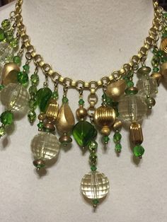 Here is a one-of-a-kind (OOAK) necklace that I made for the holidays. Looks like Christmas balls or Christmas ornaments in shades of green and gold! Materials used were faceted Lucite, painted wooden beads, metallic beads, faceted glass beads, brass beads, fluted beads and more... Vintage and contemporary findings were used to create this statement piece. The necklace looks great on and really captures the light! Perfect for those holiday parties that will be here before you know it! OOAK Vintage Green Dangle Necklaces, Green Large Beads Necklace For Party, Green Beaded Necklaces With Round Beads For Party, Green Large Beads Party Necklace, Green Faceted Bead Dangle Necklace, Green Dangle Necklace With Faceted Beads, Holiday Gold Beaded Necklace, Bohemian Green Jewelry For Holiday, Green Round Beads Jewelry For Holiday