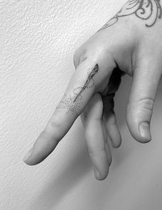 a person's hand with a small tattoo on it