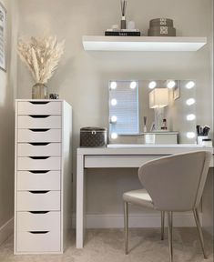 a white desk and chair in a small room with lights on the wall above it