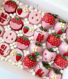 a box filled with lots of pink and white decorated strawberries