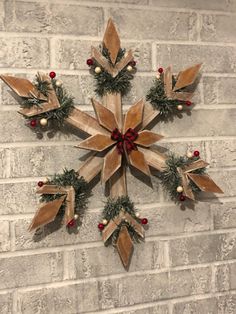 a snowflake made out of wood sitting on top of a white brick wall