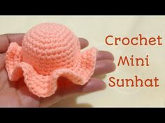 a crochet mini sunhat is in someone's hand