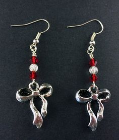 "Antique Silver Ribbon and Bow Earrings with Red and Clear Swarovski Crystals, Festive Holiday Jewelry, Simple Silver and Red Ribbon Earrings Special Holiday Earrings, perfect for gifts and seasonal jewelry Silver Tone Zinc metal alloy(Cadmium Free) Earring Size: ~1.75\" x 3/4\" All Aspen Tree Jewelry is made and stored in a smoke free environment and comes gift wrapped." Red Jewelry For Holiday Party, Red Jewelry For Holiday Jewelry Making, Red Jewelry For Christmas Celebration, Red Crystal Metal Party Earrings, Red Metal Crystal Party Earrings, Red Crystal Metal Earrings For Parties, Red Dangle Holiday Jewelry, Red Dangle Jewelry For Christmas, Nickel Free Red Crystal Earrings For Parties