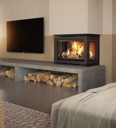 a living room with a fire place and television on the wall, next to a couch