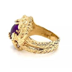 This is an impressive sculpted ring, crafted from 14k yellow gold featuring a detailed sculpted dragon with a have dome cabochon amethyst gemstone in its claws and mouth. The body of the dragon blends around the back in a tapered style band with scale like design around the band. It has the 14k gold content stamp.    Hallmark:  14k   Gemstone:  cabochon amethyst   Material: 14k yellow gold   Measurements: 0.70" across x 0.73" wide x 0.30" high       Ring size:  3  Weight:  8.7 grams Gold Amethyst Oval Cabochon Ring, Gold Amethyst Ring With Cabochon Cut, Gold Amethyst Cabochon Ring, Gold Amethyst Ring With Oval Cabochon, Ornate Yellow Gold Gemstone Rings, Collectible Yellow Gold Amethyst Ring, Ornate Gold Cabochon Rings, Ornate Gold Rings With Cabochon, Dragon Ring