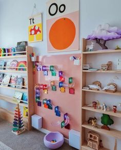 a child's playroom with toys and bookshelves on the wall in front of it