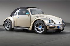 a beige and black beetle parked in a garage