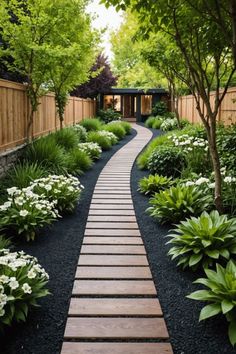 a wooden walkway in the middle of a garden with white flowers and greenery on either side