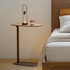 a bed with two candles on it next to a night stand