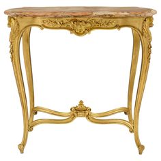 an antique console table with marble top and gold leaf trimming on the legs,