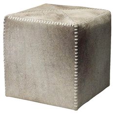 a square stool with white stitching on the top and bottom, sitting in front of a white background