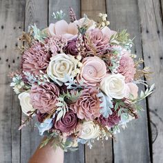 a woman holding a bouquet of flowers on top of a wooden floor