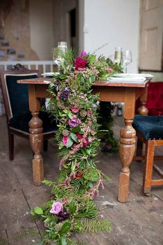 the table is covered with flowers and greenery