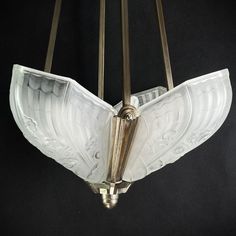 an art deco chandelier with glass shades and brass fittings on the arms