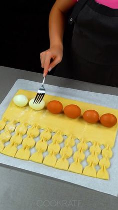 a woman is decorating an egg carton with eggs and butter on it while holding a fork