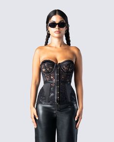 a woman wearing black leather pants and a corset with lace on the bust