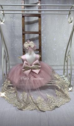 a doll sitting on top of a chair in a pink tutu skirt and matching headband