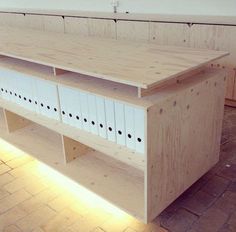 a wooden shelf with several drawers on it in a room that has brick flooring and white walls