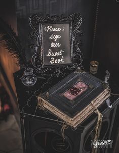 a sign that is sitting on top of a book shelf next to a candle and some books