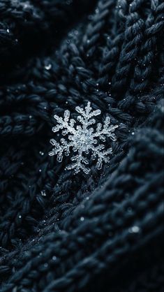 a snowflake is sitting on top of a black blanket