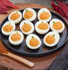 deviled eggs are arranged in the shape of pumpkins on a black platter