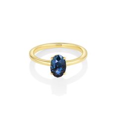 a gold ring with an oval blue sapphire stone on the front and side, set in 18k yellow gold