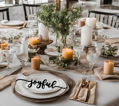 the table is set with candles, plates and napkins for an elegant wedding reception