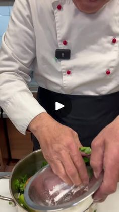 a man in a chef's uniform preparing food on top of a stovetop