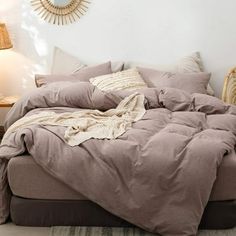 an unmade bed with pillows and blankets on it