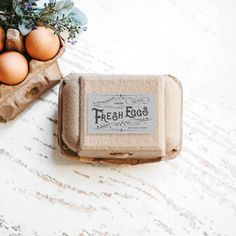 an egg carton sitting on top of a white table next to some brown eggs