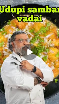 a man standing in front of a frying pan filled with food