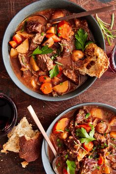 two bowls filled with stew and bread on top of a wooden table