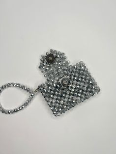 a handbag made out of beads on a white surface with a chain around it