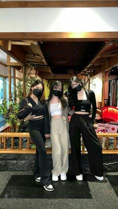 three women wearing masks standing next to each other