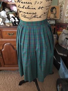 "Vintage 1970's plaid Cotton blend skirt. The main color is green with subtle Yellow, Blueish Purple Bittersweet Orange. Has a one button closure on the left side. The skirt is to small for my dressform, so it is clipped on the button side. *MORE INFORMATION BELOW* CONDITION: I note on the left side by the button, the skirt opening could use a few stitches to make the opening smaller (SEE PIX). There is supposed to be an opening in that area to be able to get the skirt on. Only closes with the o Classic Green Pleated Skirt, Retro Green Pleated Skirt, Vintage Plaid Full Skirt, Vintage Plaid Pleated Skirt, Vintage Green Full Skirt Bottoms, Vintage Green Full Skirt, Retro Green Pleated Bottoms, Blueish Purple, Vintage Clothing Boutique