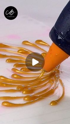 an orange marker is being used to draw gold swirls