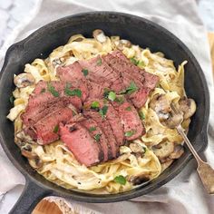 steak and mushroom pasta in a cast iron skillet