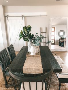 a dining room table with two chairs and a potted plant on top of it