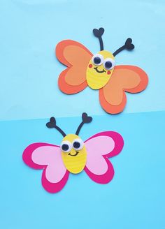 two paper butterflies with googly eyes on them