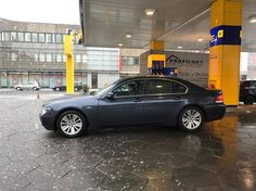 a black car parked in front of a gas station