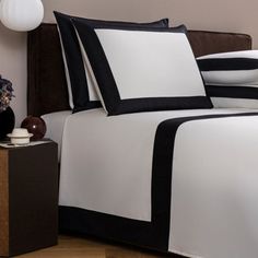 a bed with black and white sheets in a room