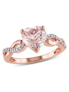 a pink heart shaped ring with diamonds on the band and an oval cut stone in the center