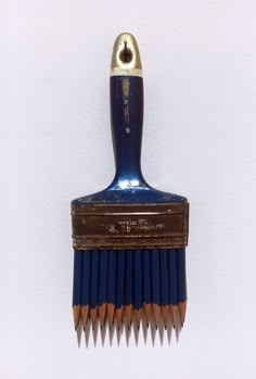 a close up of a blue and brown toothbrush on a white wall with a gold handle